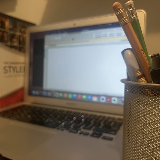 editor's workstation with pencils, books and laptop